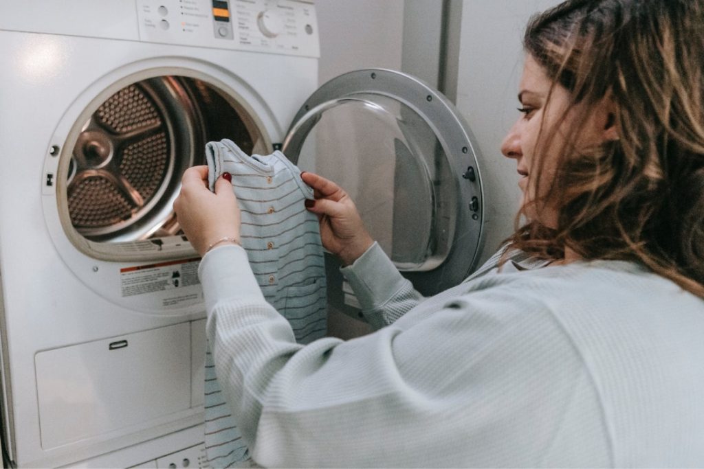 Mujer lavando con programa de lavadora para ropa de bebés